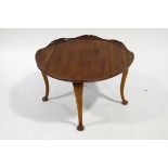 A round mahogany coffee table, with carved lily pad shaped top, on cabriole legs, 75.