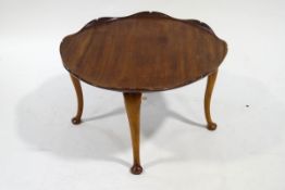 A round mahogany coffee table, with carved lily pad shaped top, on cabriole legs, 75.