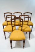 A set of six 19th century walnut dining chairs with inlaid decoration and yellow and red patterned