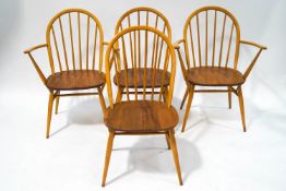 A set of four Ercol beech and elm stick back chairs, including two elbow,