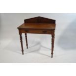 An Edwardian mahogany side table with raised back above one drawer on turned legs.