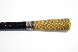 An ebonised walking cane with bone knop and white metal collar