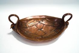 An Art Nouveau copper on brass two handled dish, modelled as two swans, their heads as the handles,