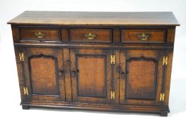 A George III style oak dresser base, three drawers over three cupboards,