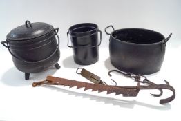 A three legged cast iron cooking pot and cover, a two handled cooking pot,