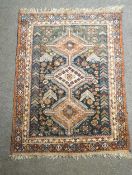 An Afghan rug with three geometric medallions on a blue field,