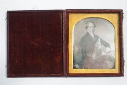 A Daguerreotype of a gentleman seated in a chair in tooled leather case, 9.25cm x 8.