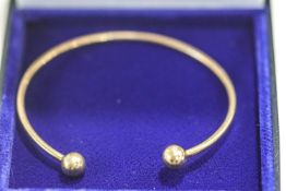 A 9ct gold torque bangle, with sphere terminals, 10.