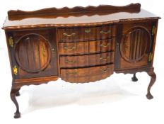 A South African sideboard, with four wavy shaped central drawers, flanked by cupboards,