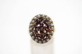 A garnet and cultured pearl cluster ring, unmarked, finger size O, 9.