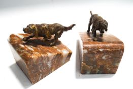 A pair of bookends, each with a patinated spelter figure of dogs on angular marble bases, 12cm high,