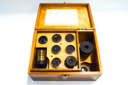 Eleven late 19th/early 20th century brass telescope lenses, and several colour filters,