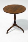 An early 19th century elm tripod table with turned yew wood column on outswept legs,