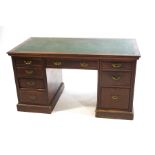 An Edwardian mahogany kneehole desk with leatherette inset top on plinth base,
