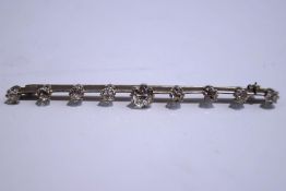 A nine stone diamond bar brooch, the eight old brilliant cuts totalling approximately 1.
