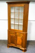 A modern walnut corner display cabinet, the glazed top over two drawers and cupboard base,