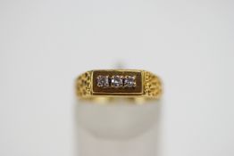 An 18 carat gold three stone diamond ring, set with uniform single cuts, finger size L, 3.