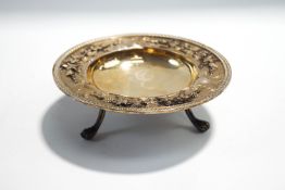 An Edwardian silver footed bon bon dish with cast border of fruiting vines, on three supports,