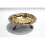 An Edwardian silver footed bon bon dish with cast border of fruiting vines, on three supports,