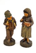 A pair of 19th century German terracotta figures of peasant children eating,