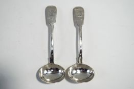 A pair of Georgian silver sauce ladles, by William Chawner, London 1824, fiddle pattern, crested,