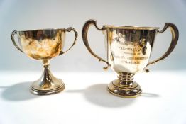 A silver two handled trophy cup, 19.5 cm high; with another two handled silver trophy cup, 18.