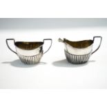 A silver cream jug and sugar bowl, Chester 1903, of oval gadrooned form, 152 g (4.