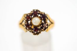 A garnet and cultured pearl cluster ring, to a 22 carat gold shank, finger size P, 8.