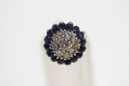 A diamond and sapphire cluster ring, the white mount unmarked,