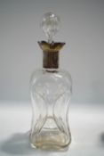 A glass decanter and stopper of pinch-wasted form, with hallmarked silver collar,