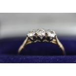 A three stone diamond ring, stamped '750', the graduated brilliant cuts totalling approximately 0.