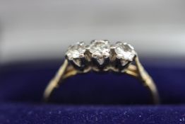 A three stone diamond ring, stamped '750', the graduated brilliant cuts totalling approximately 0.