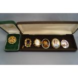 A collection of five costume jewellery brooches, including one issued by the British Museum,