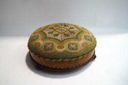 A Victorian walnut footstool with woolwork cover,