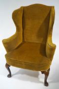 A George II style wing armchair on walnut cabriole legs