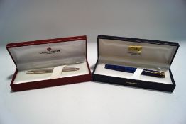 A Caran d'Ache fountain pen, blue case with gold tone trim,