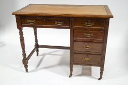 An Edwardian mahogany desk with leather inset top above an arrangement of five drawers on turned