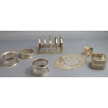 A silver four division toast rack; a silver cake lift; and four silver napkin rings; 183 g gross, 5.