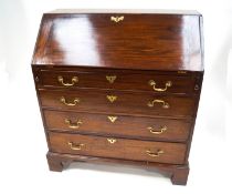 A George III mahogany bureau with fall front above three graduated drawers,