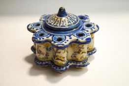 A continental faience desk inkwell with central cover to the well, decorated with animals,