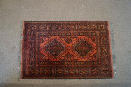 An Afghanistan wool rug, red ground with two central floral borders,