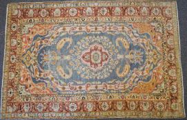 A Turkish rug with central medallions on a pale blue field,