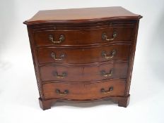 A mahogany television cabinet in the form of a George III style serpentine chest of four faux