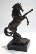 A modern bronze sculpture of a rearing horse, on a marble base,