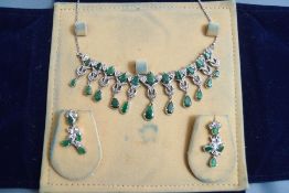 A continental diamond and emerald fringe necklace, set in unmarked white metal,