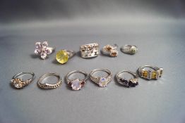 A collection of eleven silver and silver coloured stone set rings