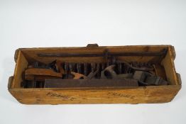 A quantity of old woodworking planes of varying size and type, a saw and winder,
