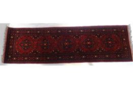 A 20th century Persian style runner with five medallions on a red field,