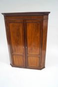 A 19th century mahogany corner cupboard with satinwood stringing and ivory escutcheons,