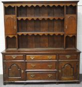 An 18th century style oak dresser with raised rack,